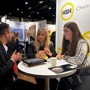 HSH Chemie team at SEPAWA 2024 booth engaging with an attendee, discussing chemical distribution and personal care ingredients.