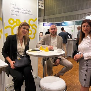 Attendees gather at HSH Chemie’s SEPAWA 2024 booth, discussing chemical distribution and cosmetic raw materials around a table.